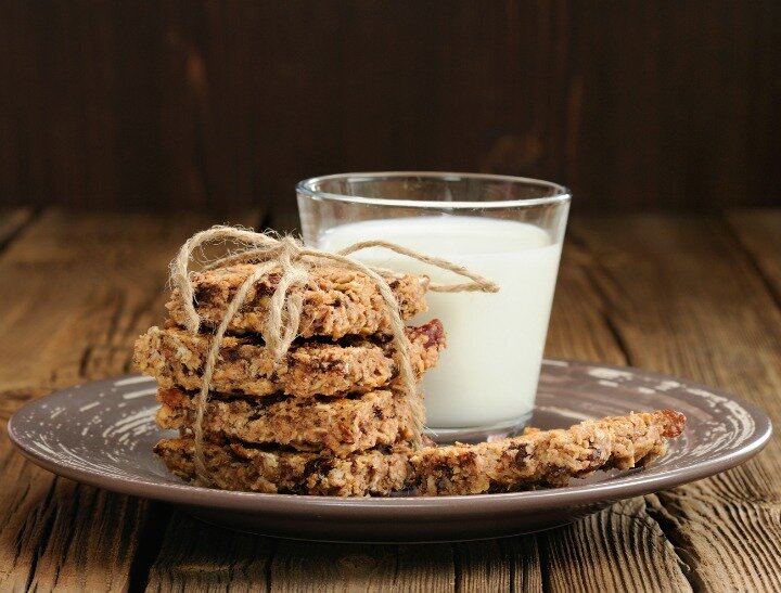 Granola bars with glass of milk on wooden background horizontal